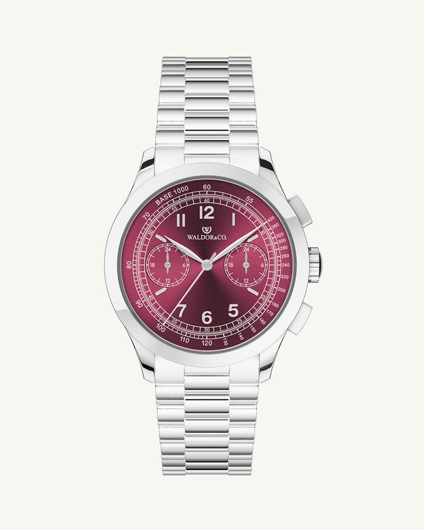 A round mens watch in rhodium-plated silver from Waldor & Co. with a burgundy colored sunray dial and a second hand. Seiko movement. The model is Chrono 39 Porto Cervo.