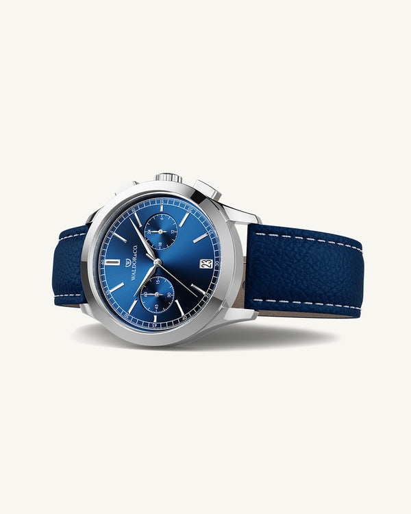 A round mens watch in rhodium-plated silver from Waldor & Co. with blue sunray dial and genuine blue leather strap. A second hand. Seiko movement. The model is Chrono 39 Sardinia 39mm.