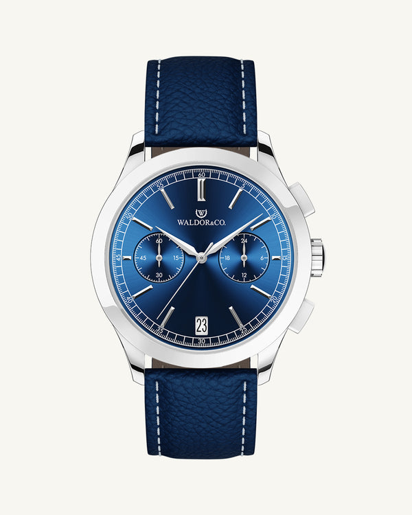 A round mens watch in rhodium-plated silver from Waldor & Co. with blue sunray dial and genuine blue leather strap. A second hand. Seiko movement. The model is Chrono 44 Sardinia 44mm.