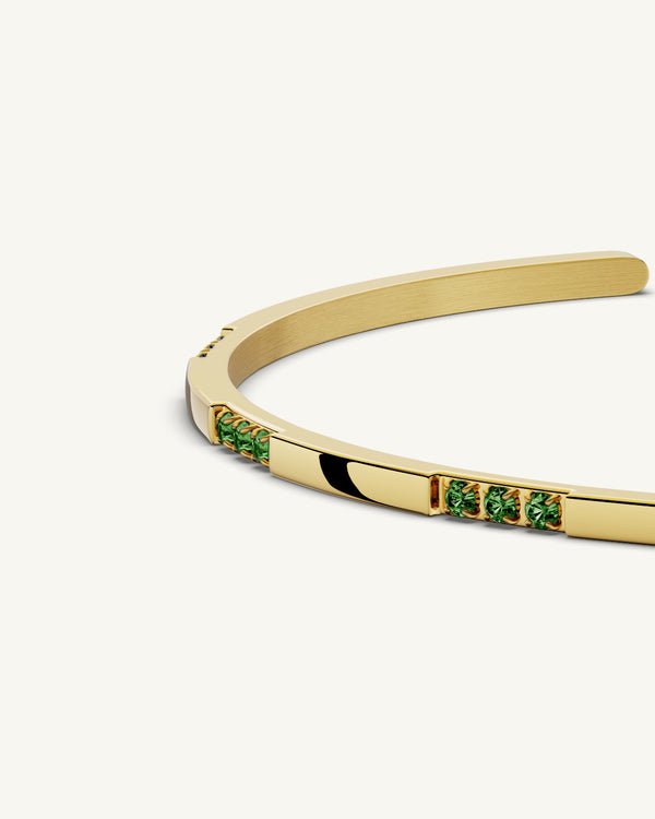 A Bangle in 14k gold-plated 316L stainless steel with green stones from Waldor & Co. One size. The model is Opulent Bangle Polished.