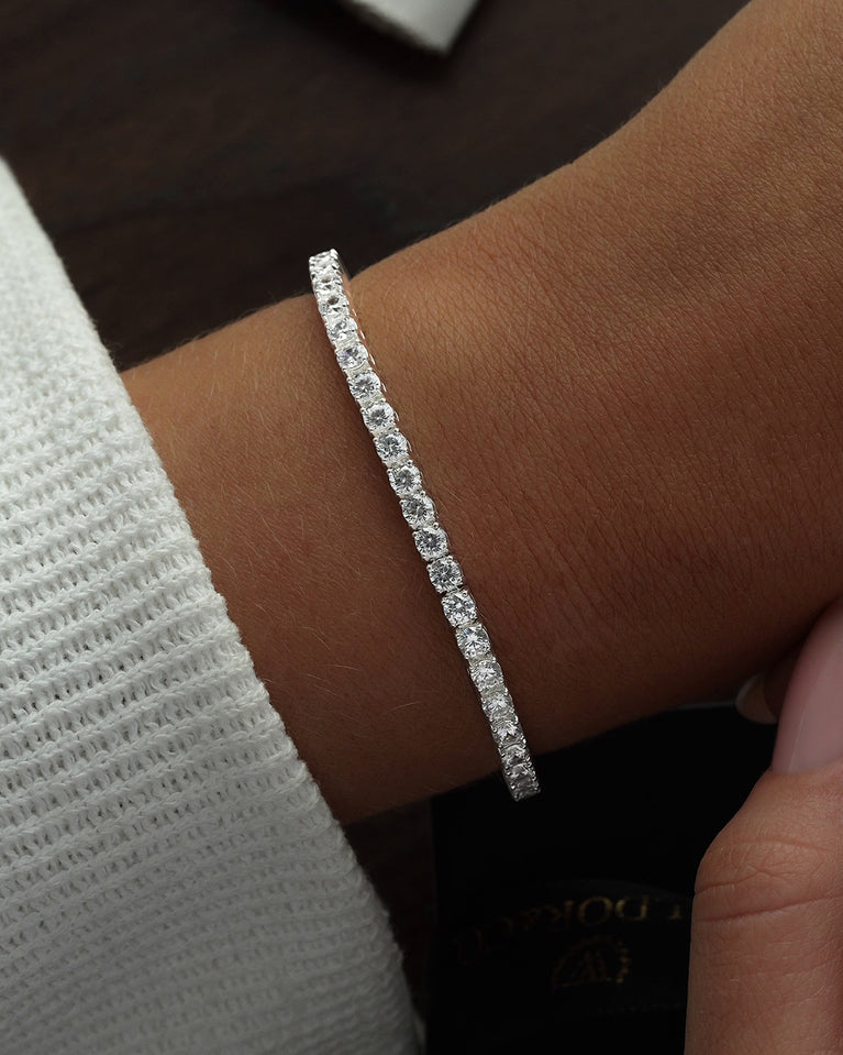 A polished stainless steel chain in silver with turquoise stones from Waldor & Co. The model is Tennis Chain Polished