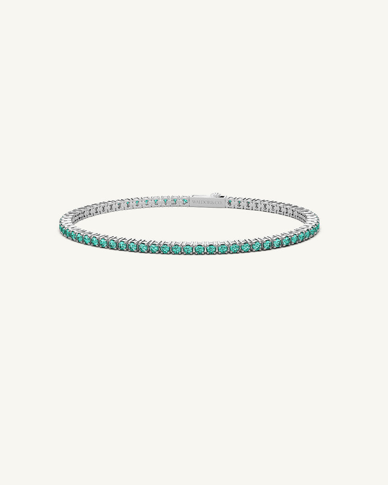 A polished stainless steel chain in silver with turquoise stones from Waldor & Co. The model is Tennis Chain Polished