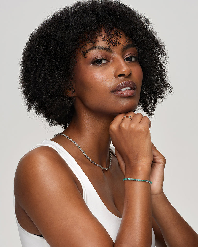 A polished stainless steel chain in silver with turquoise stones from Waldor & Co. The model is Tennis Chain Polished