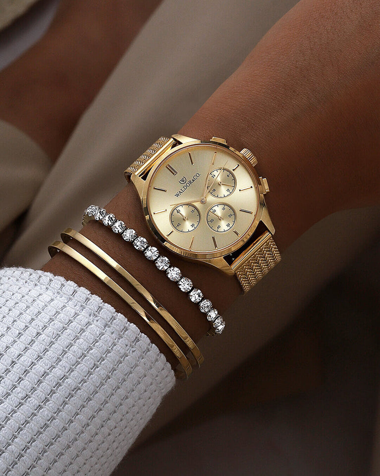 A round womens watch in 14k gold-plated 316L stainless steel from Waldor & Co. with gold dial and a second hand. Seiko movement. The model is Epoch 36 Formentera 36mm.