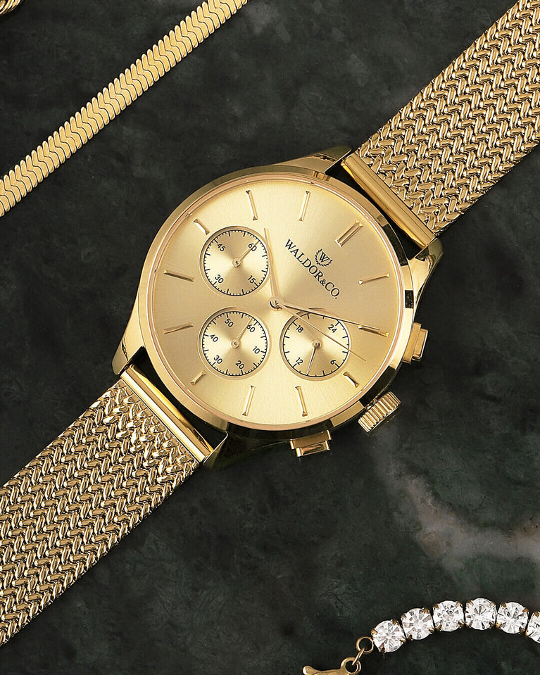 A round womens watch in 14k gold-plated 316L stainless steel from Waldor & Co. with gold dial and a second hand. Seiko movement. The model is Epoch 36 Formentera 36mm.