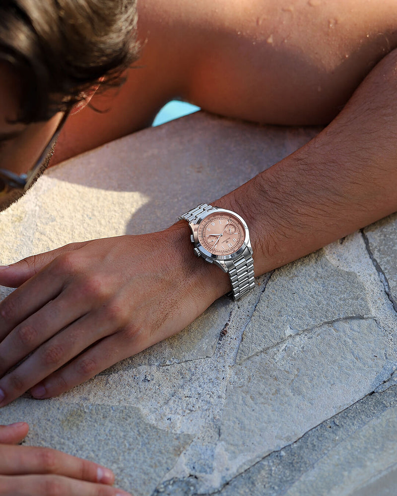 A round mens watch in Rhodium-plated 316L stainless steel from Waldor & Co. with Salmon sunray dial in brass sunray and a second hand. Seiko movement. The model is Chrono 39 Porto Cervo Ltd. Edition.