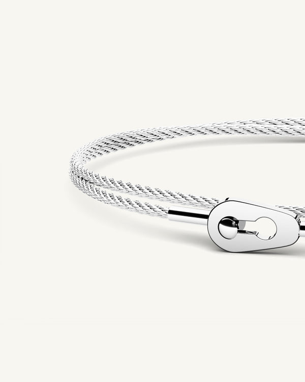 A polished stainless steel bangle in silver from Waldor & Co. One size. The model is Como Bangle Dual Polished