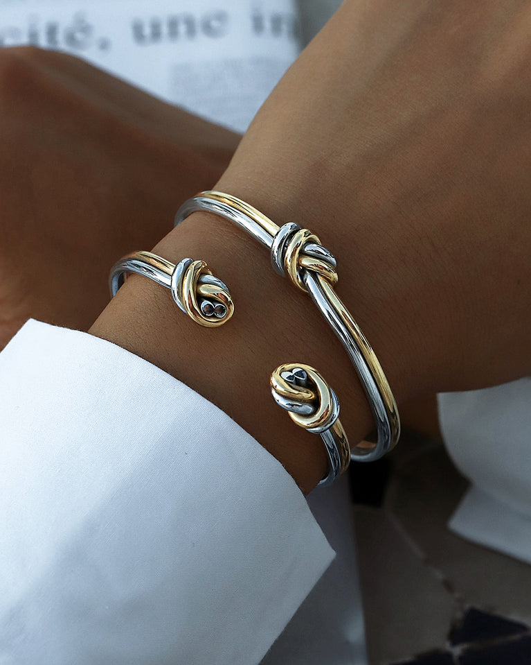 A Bangle in 14k-gold plated and silver polished 316L stainless steel from Waldor & Co. One size. The model is Dual Knot Bangle Polished.