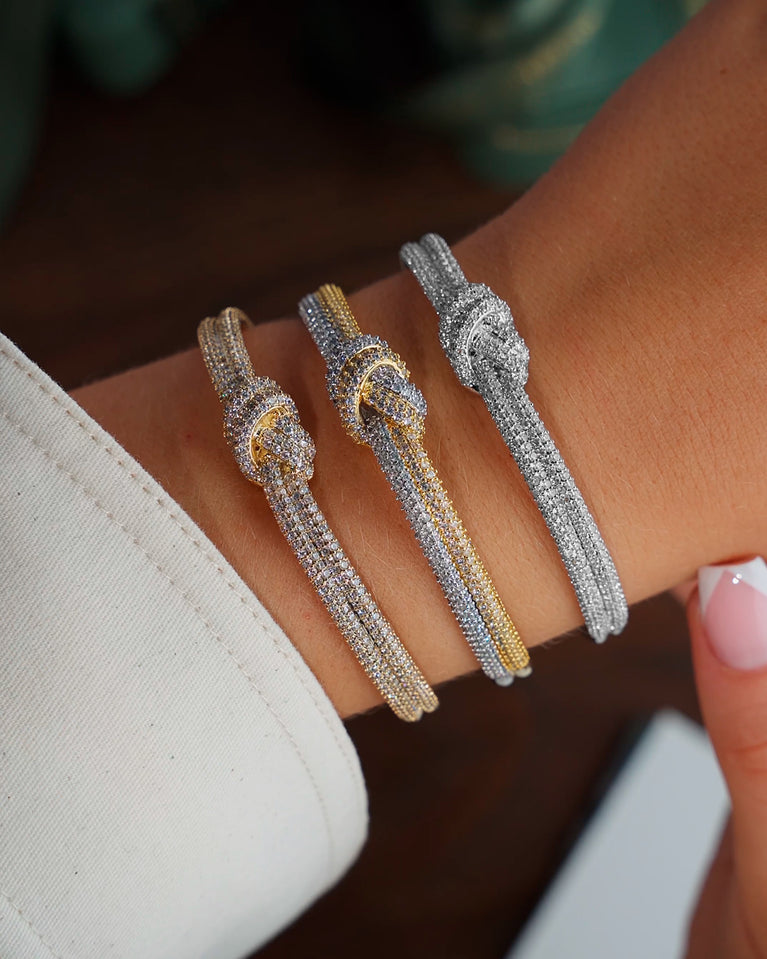  a trio of bangle in 14k-gold plated copper and silver plated copper from Waldor & Co. One size. The model is Dual Knot Bangle Pavè.