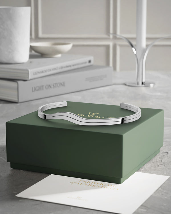A polished stainless steel bangle in silver from Waldor & Co. One size. The model is Azur Bangle Polished.
