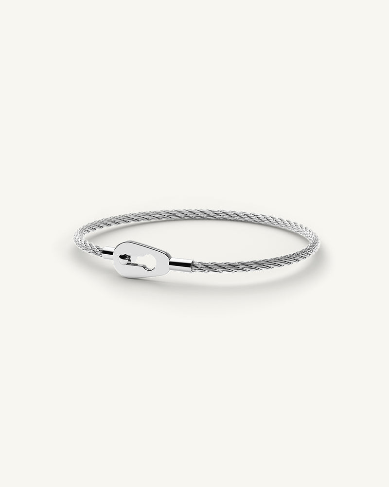A polished stainless steel bangle in silver from Waldor & Co. One size. The model is Como Bangle Polished