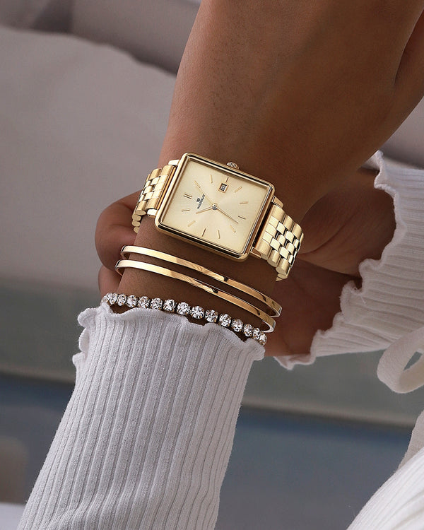  A square womens watch in gold from Waldor & Co. with silver sunray dial and a second hand. Seiko movement. The model is Delight 32 Chelsea 28x32mm.
