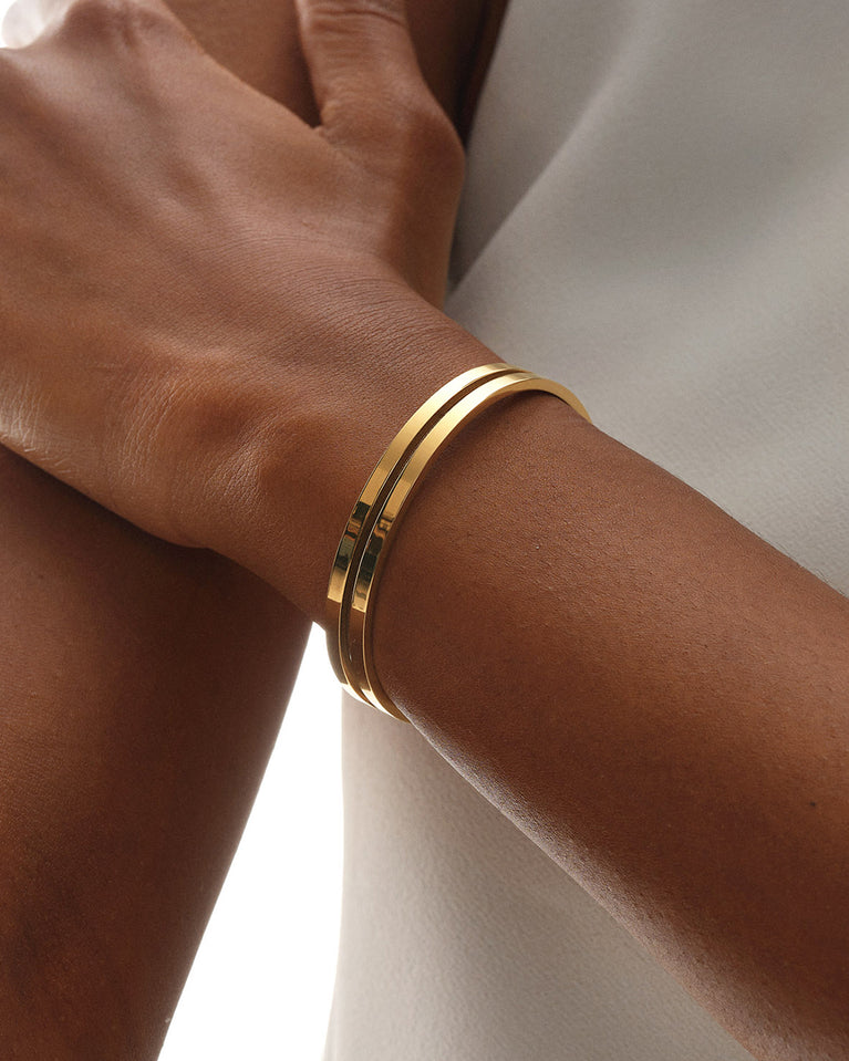 A Bangle in 14k gold plated 316L stainless steel from Waldor & Co. One size. The model is Dual Bangle Polished.