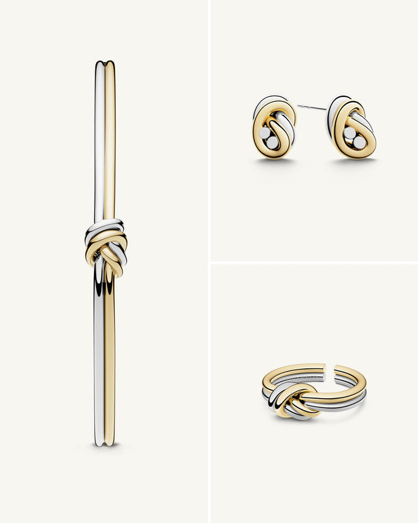 A polished stainless steel jewelry set in 14k gold from Waldor & Co. One size. The model is Dual Knot Ring.
