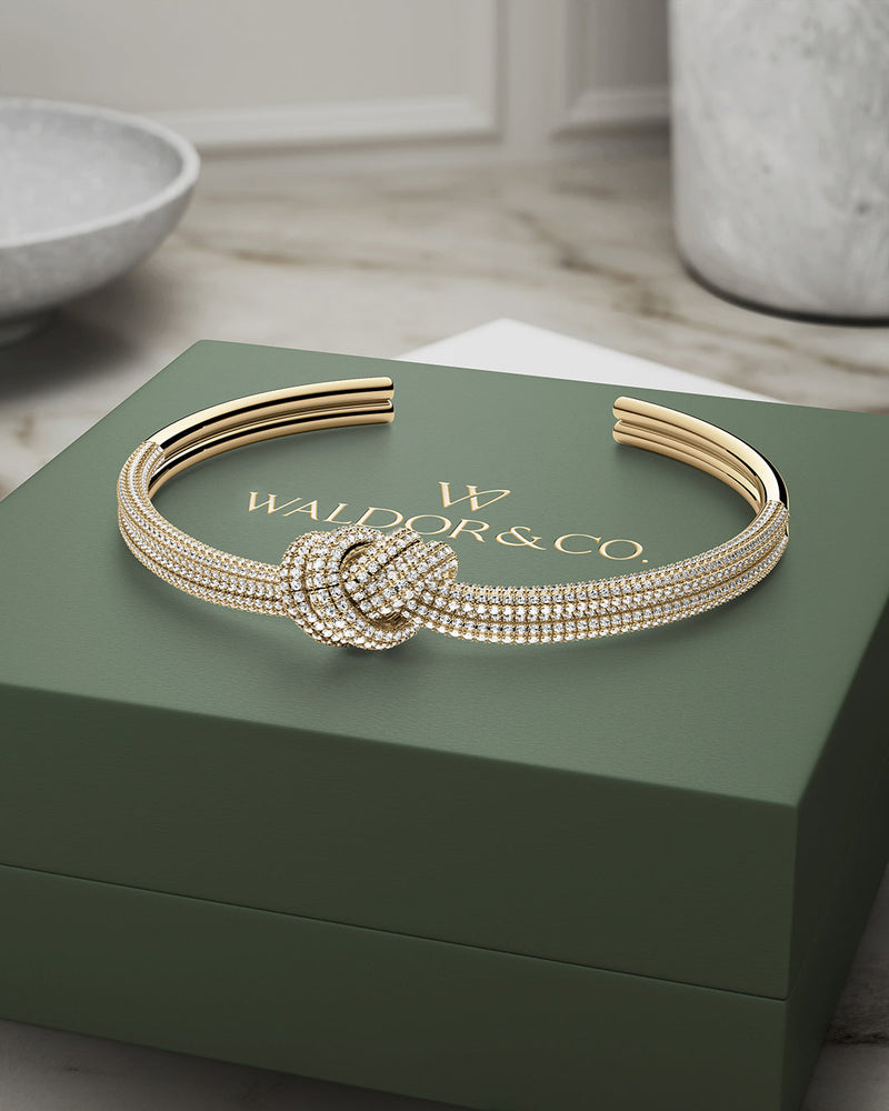 A Bangle in 14k-gold plated copper from Waldor & Co. One size. The model is Dual Knot Bangle Pavè.