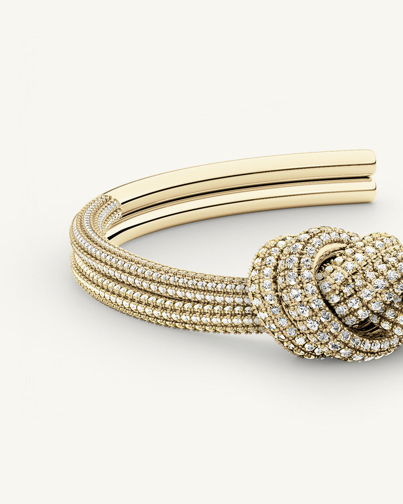 A Bangle in 14k-gold plated copper from Waldor & Co. One size. The model is Dual Knot Bangle Pavè.