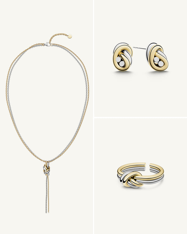 A polished stainless steel jewelry set in 14k gold from Waldor & Co. One size. The model is Dual Knot Ring.