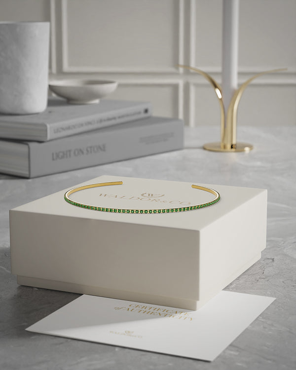 A Bangle in 14k gold-plated 316L stainless steel with green stones from Waldor & Co. One size. The model is Dulcet Bangle Polished.