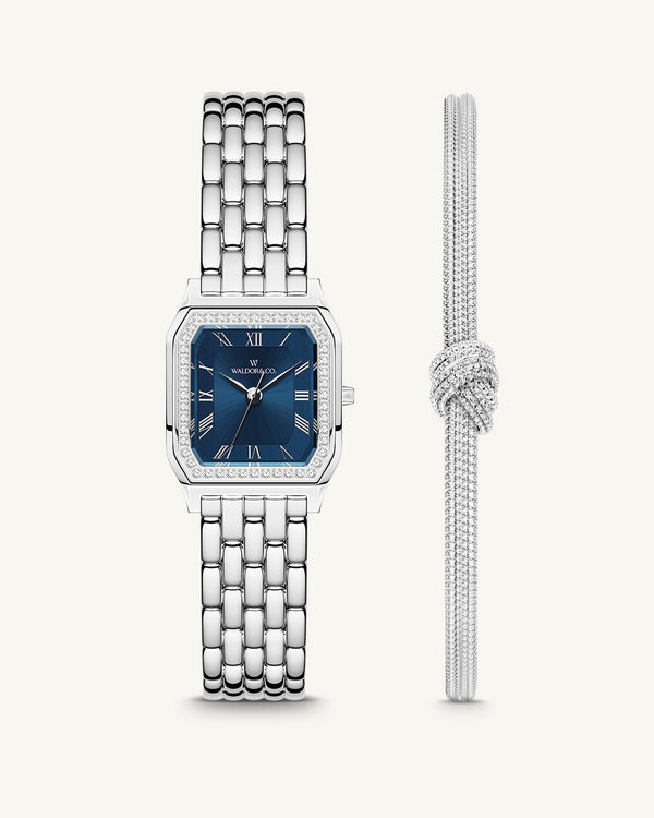 A square womens watch in Rhodium-plated 316L stainless steel from Waldor & Co. with dark blue dial. Bezel with premium crystals. Diamond Cut Sapphire Crystal glass dial. Seiko movement. The model is Eternal 22 Bellagio Pavè.