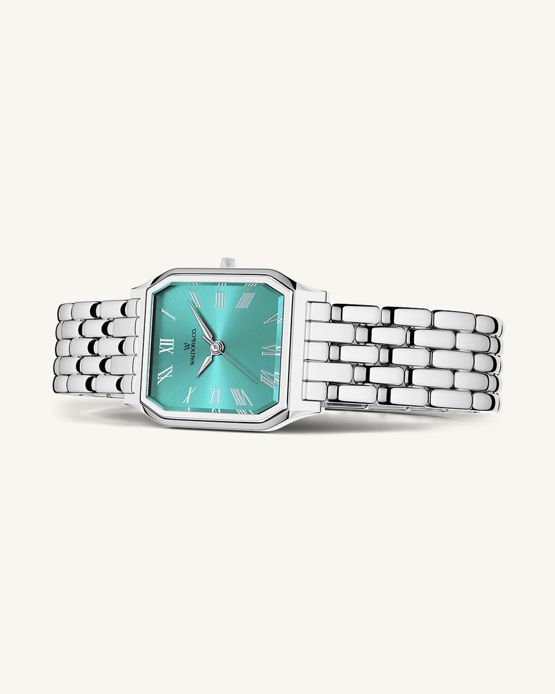 A square womens watch in Rhodium-plated 316L stainless steel from Waldor & Co. with turquoise Diamond Cut Sapphire Crystal glass dial. Seiko movement. The model is Eternal 22 Bellagio.