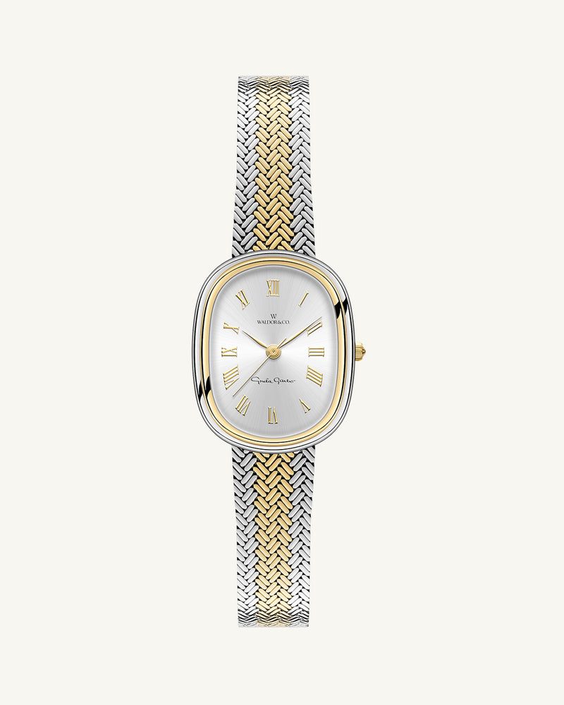 An oval womens watch created under exclusive license from the Greta Garbo™ estate. Featuring a silver sunray dial with gold Roman numerals, framed in a dual-tone case. Seiko movement. 