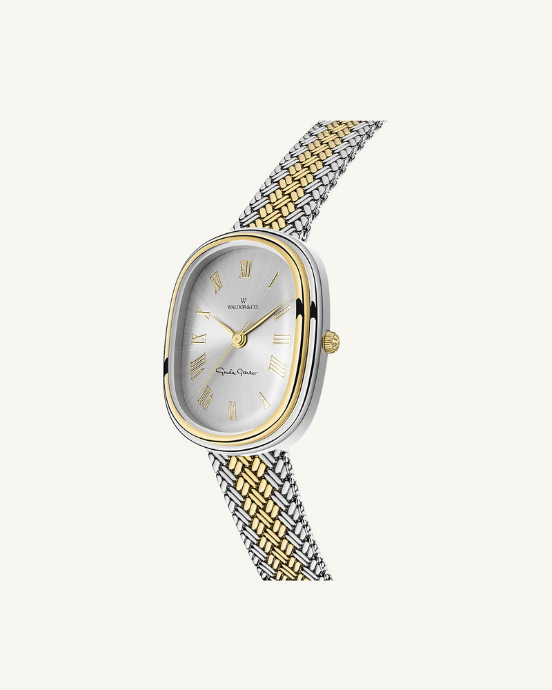 An oval womens watch created under exclusive license from the Greta Garbo™ estate. Featuring a silver sunray dial with gold Roman numerals, framed in a dual-tone case. Seiko movement. 