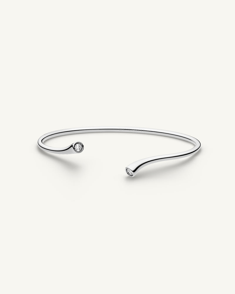 A polished stainless steel bangle from Waldor & Co. One size. The model is Delight Bangle. 