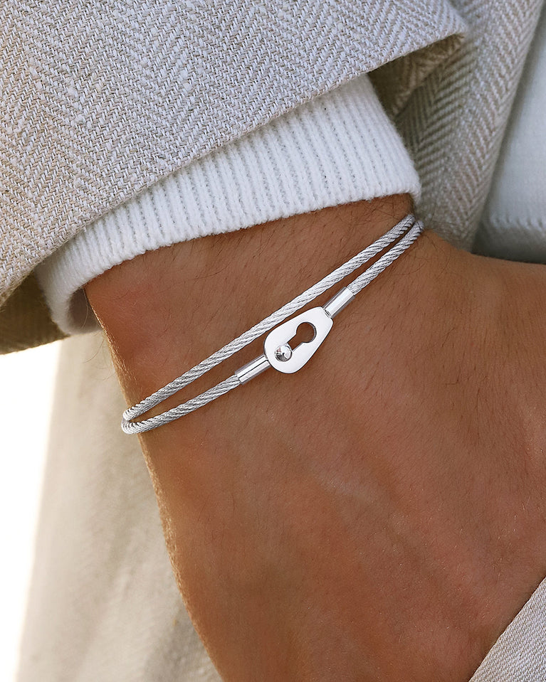  A polished stainless steel bangle in silver from Waldor & Co. One size. The model is Como Bangle Dual Polished