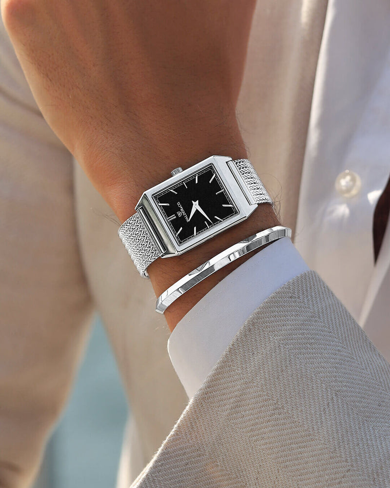 A square mens watch in rhodium-plated silver from Waldor & Co. with black sunray dial. Seiko movement. The model is Conceptual 37 Antibes 29x43mm.